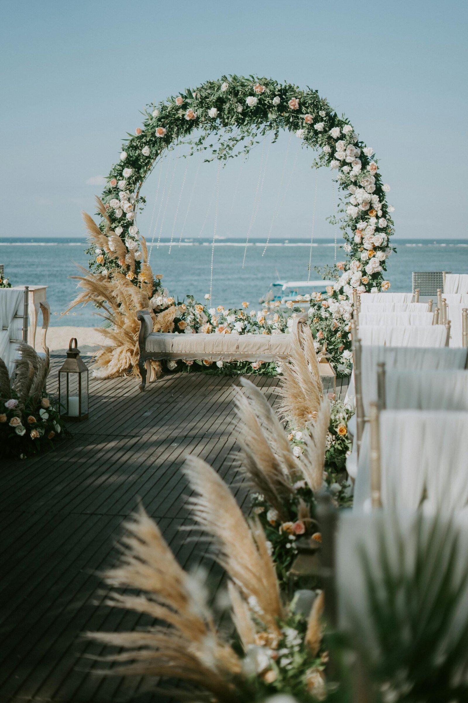 A beautiful flower arch setup for a wedding by the seaside. Elegant and serene decor with ocean views.